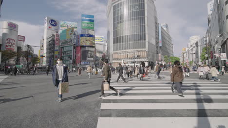 Hyperlapse-Of-Japanese-People-At-Shibuya-Crossing-On-A-Busy-Sunny-Day-During-Pandemic-In-Tokyo---low-level-shot