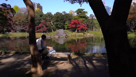 Slow-motion-slider-of-Japanese-businessman-having-lunch-break-inside-park