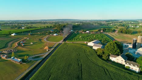Steam-Train-Puffing-along-by-Amusements-in-Amish-Countryside-as-seen-by-Drone