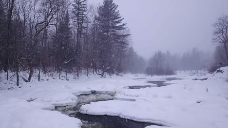 SLOW-MOTION-icy-river-winding-through-a-snow-storm
