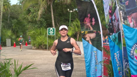 Slow-motion-of-a-female-triathlon-athlete-finishing-the-competition-looking-completely-exhausted