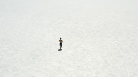 Drone-footage-of-a-man-running-on-salt-flats-in-Death-Valley,-California
