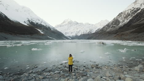 Reveal-shot-of-a-girl-photographing-Hooker-Lake-in-New-Zealand-on-a-cold-winters-afternoon