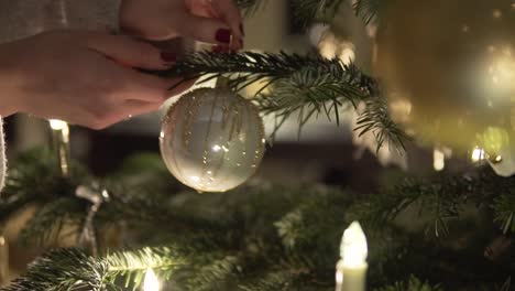 SLOW-MOTION:-Hanging-silver-Christmas-Ball-on-Christmas-Tree-with-candles