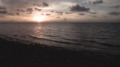 Küstenstrand-Sonnenaufgangslandschaft-Im-Süden-Floridas-Mit-Felsen-Im-Vordergrund-Und-Meer-Und-Wolken-Im-Hintergrund