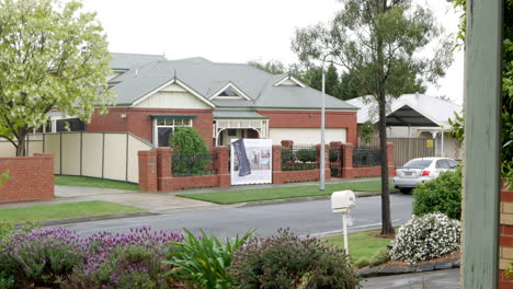 Long-view-of-an-auction-flag-waving-in-the-breeze-at-a-suburban-house-in-a-small-street