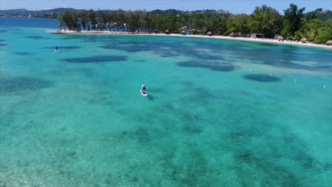 Aereal-view-of-people-paddleboarding-near-a-resort’s-beach-on-the-Honduran-caribbean-sea