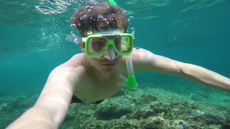 Young-man-snorkeling-in-beautiful-ocean-water,-action-cam-shot