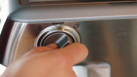 Hand-turning-hot-water-dispenser-on-Espresso-machine-off