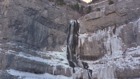 A-high-mountain-waterfall-with-frozen-water-to-the-sides---dolly-in