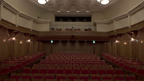 Lines-of-chairs-and-chandelier-at-Oji-Hall,-Ginza,-Tokyo,-Japan,-2018