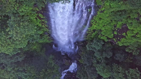 Aerial-Shot-bird's-eye-view-of-beautiful-sunny-waterfall-and-rising-up-from-it-and-tilting-up,-Meseta-de-Chorcha,-Chiriqui,-Panama