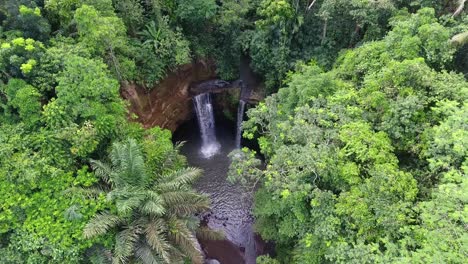 High-waterfall-with-pond-hidden-in-the-jungle,-top-down-drone-shot