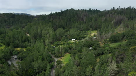 Aerial-drone-flyover-of-a-small-village-with-homes-and-cottages-nestled-into-the-redwood-forests-in-Northern-California