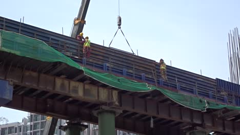 Construction-workers-working-at-height-installing-reinforcement-bar-and-form-work-at-the-construction-site