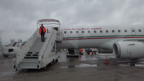 Aeropuerto-De-París-Orly,-Visto-Desde-Un-Transbordador-De-Pasajeros-Frente-A-Un-Avión-De-Royal-Air-Maroc,-Empleado-En-Uniforme-Que-Desciende-Los-Escalones-De-La-Plataforma-Para-Autorizar-El-Embarque