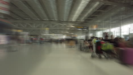 time-lapse-dolly-shot-with-abstract-motion-blur-of-a-cart-ride-through-the-busy-passenger-crowds-of-Suvarnabhumi-International-Airport's-Departure-Hall