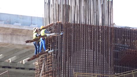 Bauarbeiter,-Die-In-Der-Höhe-Arbeiten-Und-Auf-Der-Baustelle-Stahlbewehrungsstäbe-Herstellen