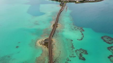 Aerial-view-of-car-bridge-over-turquoise-water-on-tropical-island