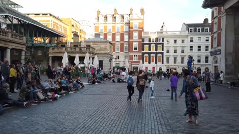 Exterior-of-Covent-Garden,-showing-street-performer-and-crowds-in-this-atmospheric-tourist-destination-of-London,-UK