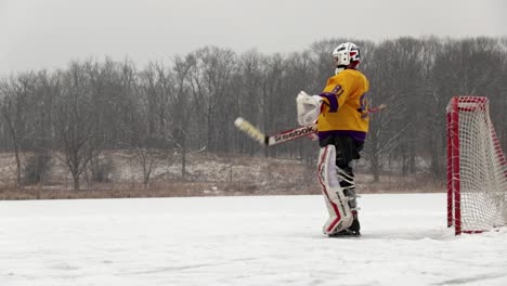 A-closer-view-from-the-side-of-a-pond-hockey-goal-keeper-as-he-follows-the-action