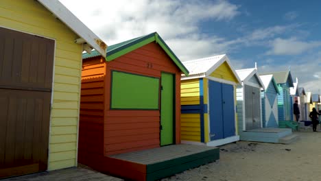 Tourists-walking-and-taking-photo-at-Brighton-Bathing-Boxes,-Melbourne,-Australia