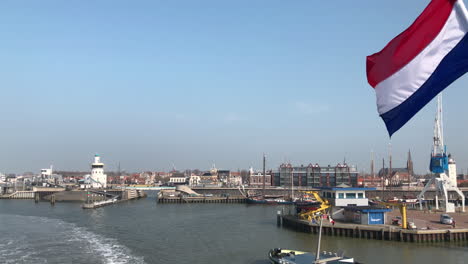 Wunderschönes-Typisch-Niederländisches-Hafendorf-Mit-Flagge-Und-Materialtransportboot
