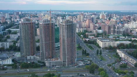 Vista-Aérea-De-Rascacielos-Con-Una-Grúa-En-Construcción-Con-Paisaje-Urbano-De-Fondo-En-Kiev,-Ucrania