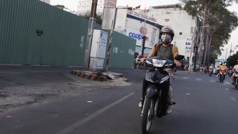 Mujer-Conduce-Una-Moto-En-La-Concurrida-Calle-Del-Sudeste-Asiático,-Ho-Chi-Minh,-Vietnam