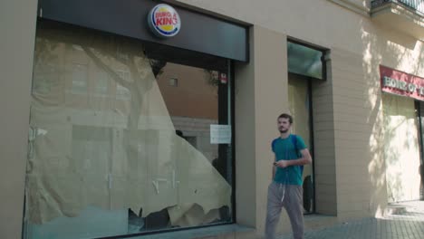 Junger-Mann-Geht-An-Vorübergehend-Geschlossenem-Burger-King-In-Sevilla,-Spanien-Vorbei