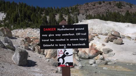 Una-Señal-De-Peligro-Que-Advierte-A-Todos-Los-Visitantes-Que-Permanezcan-En-La-Pasarela-Peatonal-En-La-Ruta-De-Senderismo-Bumpass-Hell-En-El-Parque-Nacional-Volcánico-Lassen,-California