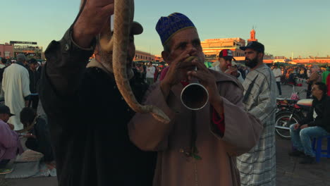 Plano-Medio-De-Dos-Encantadores-De-Serpientes-En-Djemaa-El-Fna,-Marrakech,-Marruecos