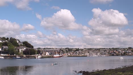 Lapso-De-Tiempo-De-Nubes-Blancas-Que-Pasan-Sobre-El-Cielo-Azul-Soleado-Y-El-Río-Con-Kinsale-Distante,-Ciudad-En-Irlanda