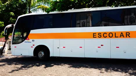 A-left-to-right-panning-shot-of-a-school-bus-in-the-downtown-area-of-Pirenopolis,-Brazil