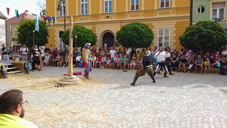 Cámara-Lenta-De-Lucha-Con-Espadas-Medievales-En-La-Plaza-Para-Divertir-Al-Rey,-Festival-Preludij-En-Slovenj-Gradec-Eslovenia