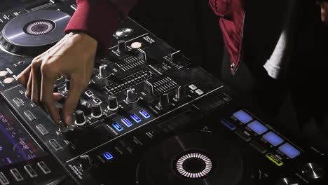 Close-up-DJ's-hand-pick-up-headphone-and-turning-knob-dj-instrument
