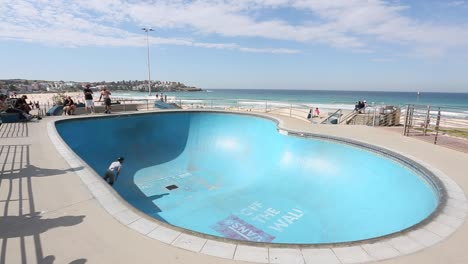 Freizeitskater,-Der-An-Einem-Sonnigen-Frühlingstag-Im-Skatepark-Am-Bondi-Beach-In-Sydney,-Australien,-Skateboard-Fährt