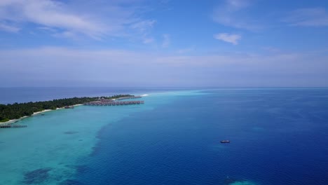 Océano-Azul-De-Maldivas-Que-Muestra-Un-Cuerpo-De-Agua-Abierto-Bajo-Un-Cielo-Azul-Brillante-Que-Rodea-La-Isla-Desde-Una-Distancia---Toma-Aérea