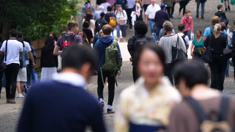 Toma-En-Cámara-Lenta-De-Una-Multitud-De-Turistas-Caminando-En-El-Parque-Yoyogi,-Tokio