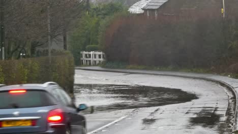 Vehicles-detour-around-stormy-flash-flooded-road-corner-bend-UK