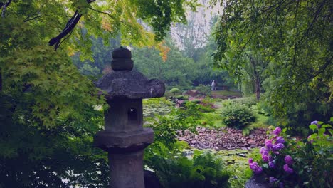 Lantern-in-japanese-garden,-purple-flowers,-lush-and-tranquil-scene