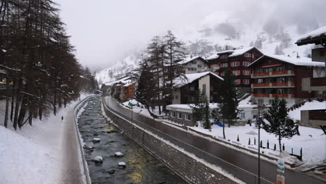 Schneebedecktes-Zermatt,-Schweiz,-Mit-Einer-Wasserstraße,-Die-Zum-Abfließen-Führt