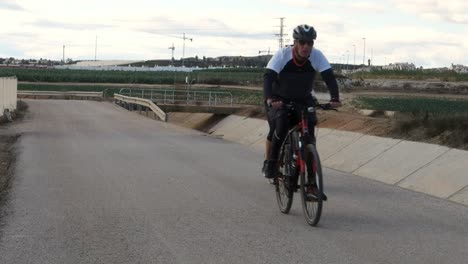 Ciclista-Haciendo-Ejercicio-Diario-A-Lo-Largo-De-La-Carretera-Junto-Al-Acueducto-En-España,-Cámara-Lenta