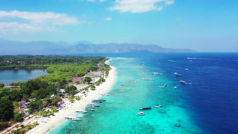 Paradise-exotic-beach-with-white-sand-washed-by-blue-turquoise-sea,-boats-floating-on-shore-of-tropical-island-in-gili-Meno