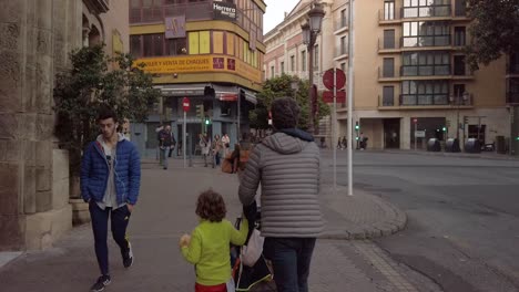 Parents-walk-with-children-in-downtown-Seville,-Spain,-Slowmo-Street-Scene