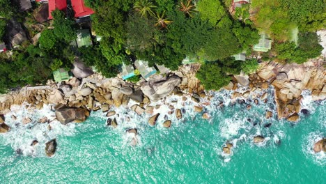 Beautiful-destination-for-summer-holidays-on-tropical-island-with-trees-forest-and-rocky-shoreline-with-cliffs-splashed-by-ocean-waves,-Thailand