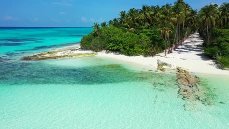 Paradise-tropical-island-with-palm-trees-forest,-white-sand-of-exotic-beach-washed-by-clear-turquoise-sea-in-Maldives