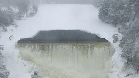 Elevating-shot-of-waterfall-during-snowy-day-in-the-countryside-of-Canada