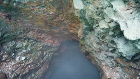 HD-Hawaii-Kauai-Boating-on-the-ocean-floating-along-ocean-cave-wall-and-floating-out-of-cave-to-reveal-waterfall-falling-into-the-ocean