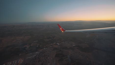 Blick-Aus-Dem-Flugzeugfenster-Auf-Den-Linken-Flügel-Des-Flugzeugs-Beim-Abbiegen,-Goldene-Stunde